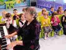 Woman Playing the Piano to Children at Colel Chabad Childcare Center