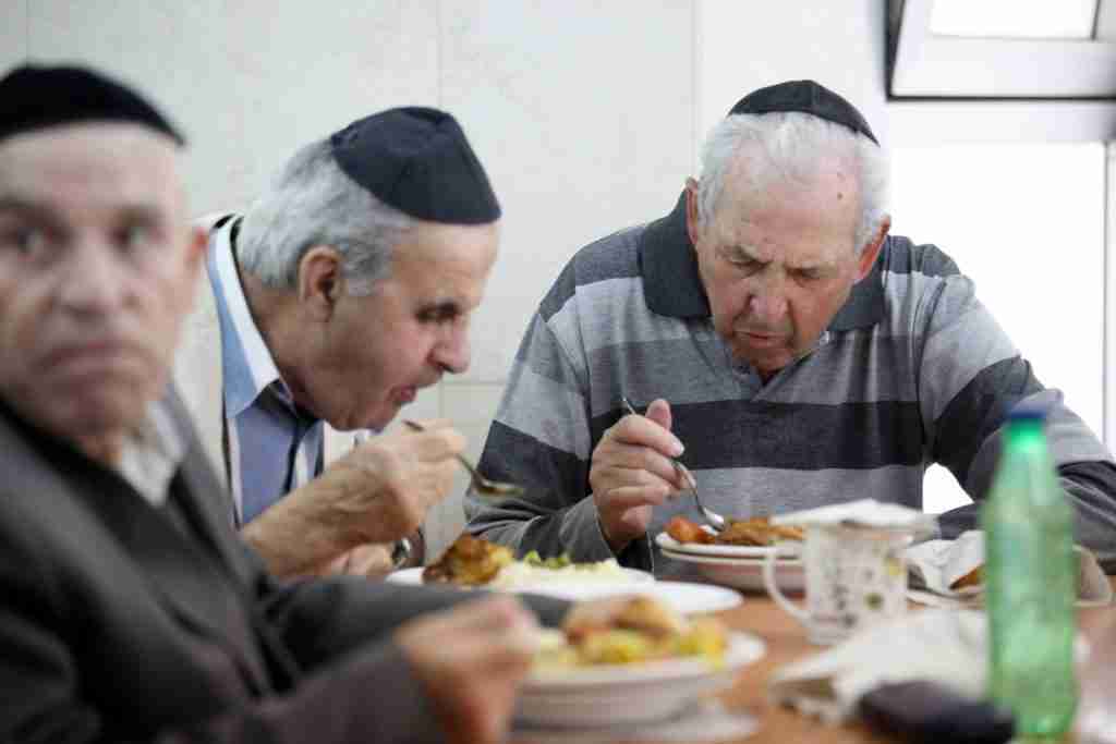 Three Men Enjoying a Seudas Aniyim Meal Together